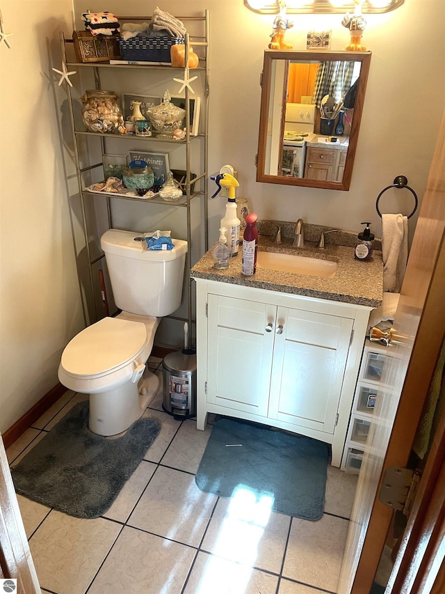 bathroom featuring vanity, tile patterned flooring, toilet, and washer / clothes dryer