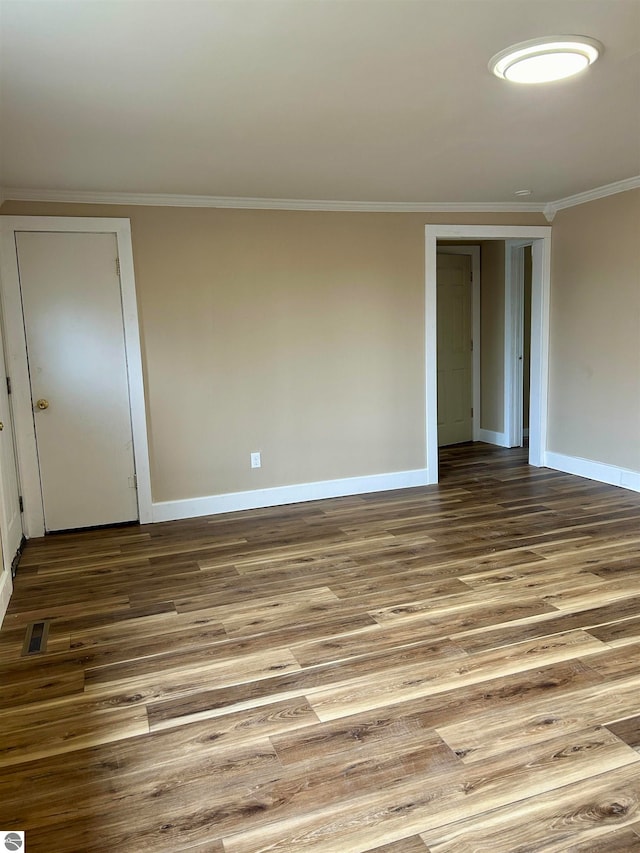 empty room featuring crown molding and hardwood / wood-style floors