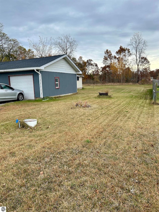 view of yard with a garage and an outbuilding