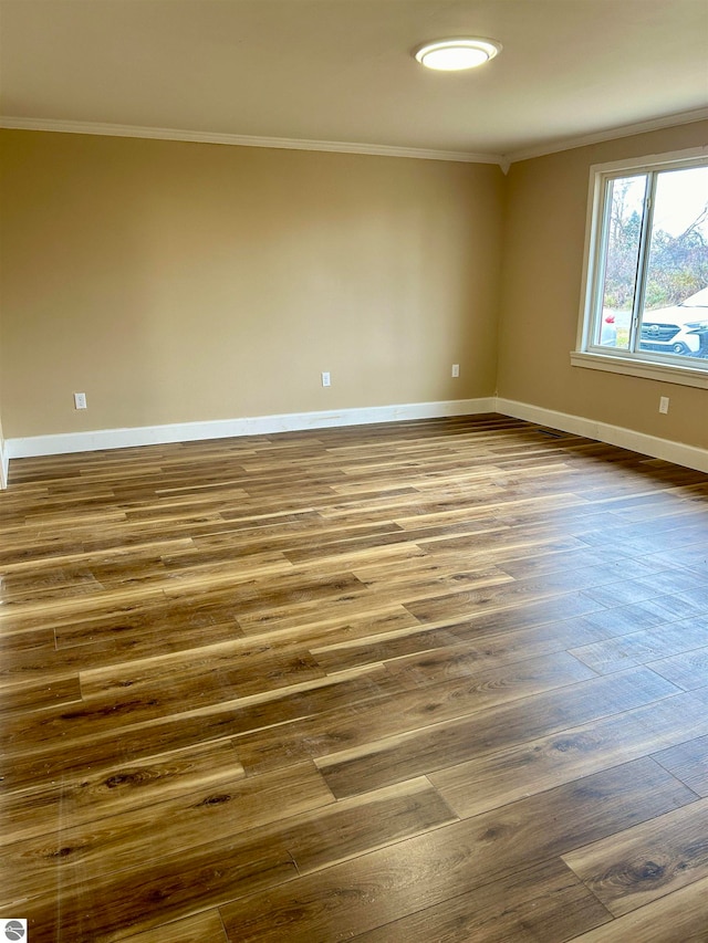 unfurnished room with ornamental molding and dark wood-type flooring