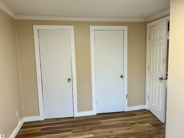 unfurnished bedroom with dark wood-type flooring and crown molding