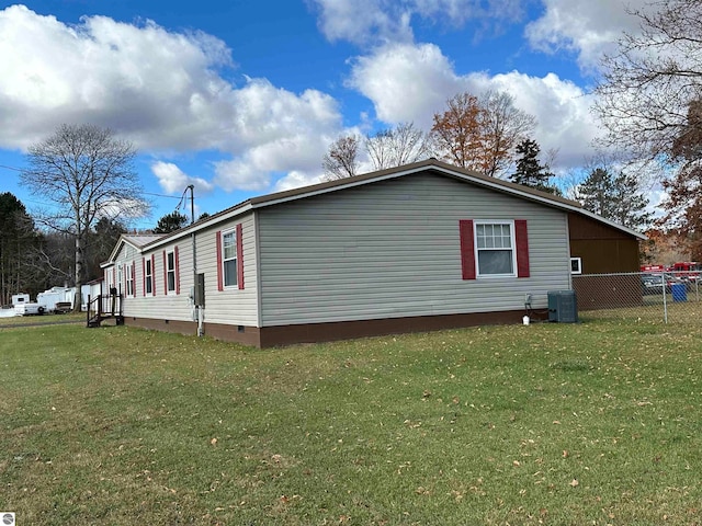 view of side of home featuring crawl space, a yard, central AC unit, and fence