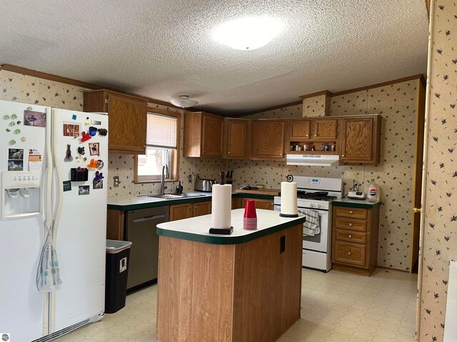 kitchen with white appliances, light floors, wallpapered walls, a sink, and under cabinet range hood