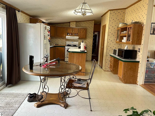 kitchen featuring brown cabinets, white appliances, wallpapered walls, lofted ceiling, and light floors