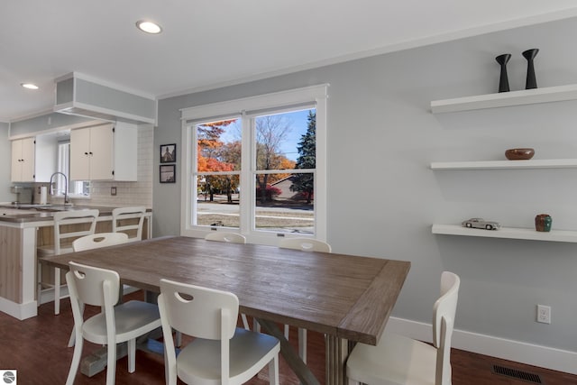 dining area featuring sink and dark hardwood / wood-style flooring