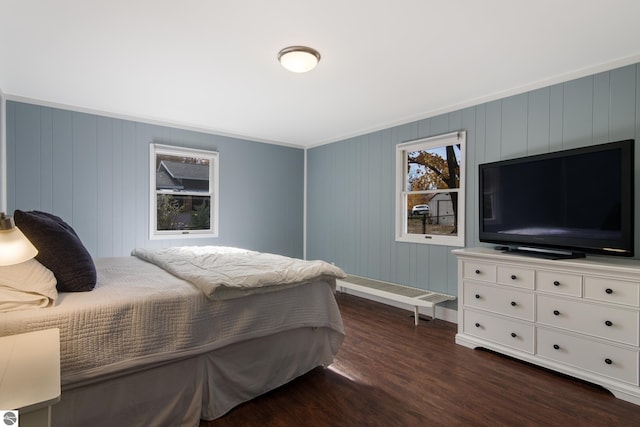 bedroom featuring ornamental molding, dark hardwood / wood-style floors, and wood walls