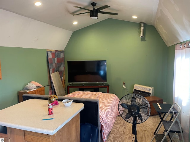 bedroom with ceiling fan, vaulted ceiling, and hardwood / wood-style floors