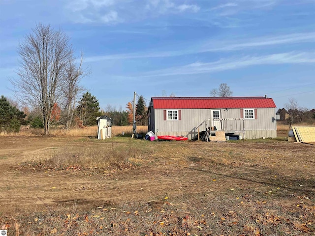 rear view of house with a storage shed