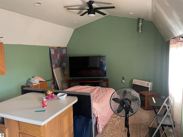 bedroom featuring ceiling fan, heating unit, and vaulted ceiling