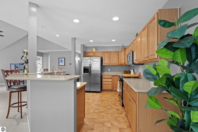 kitchen with light carpet, a kitchen island, a kitchen breakfast bar, vaulted ceiling, and stainless steel appliances