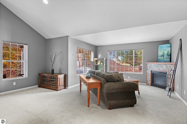 living room featuring a tiled fireplace, light carpet, and lofted ceiling