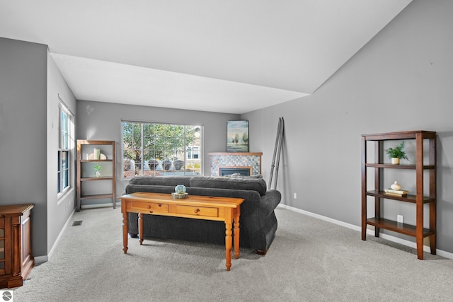 bedroom featuring light carpet, a fireplace, and vaulted ceiling