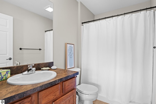 bathroom with toilet, vanity, and tile patterned flooring