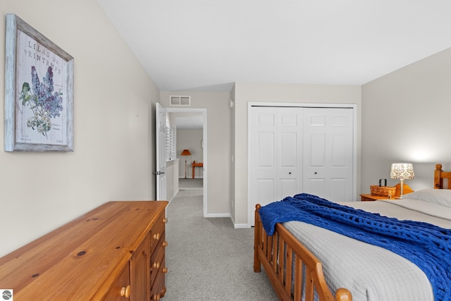 bedroom featuring a closet, light carpet, and lofted ceiling