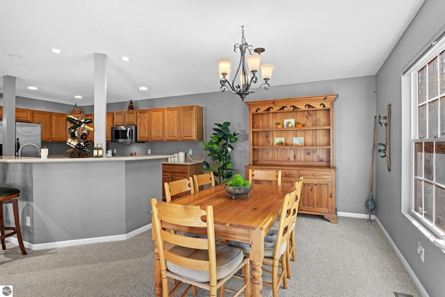 carpeted dining room featuring a chandelier