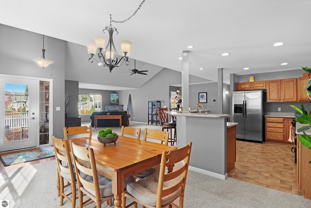 carpeted dining room with sink, lofted ceiling, and ceiling fan with notable chandelier