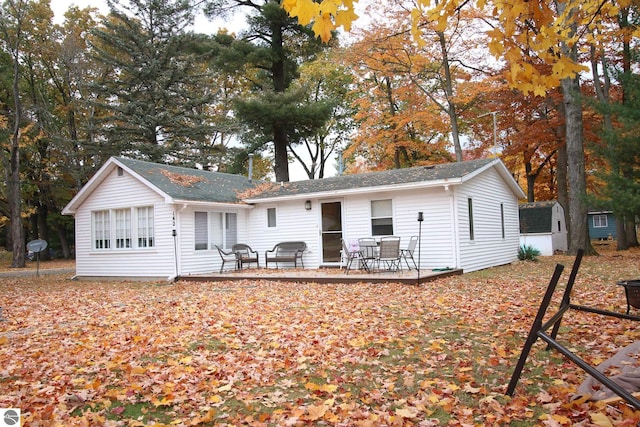 rear view of property with a patio area and a storage shed