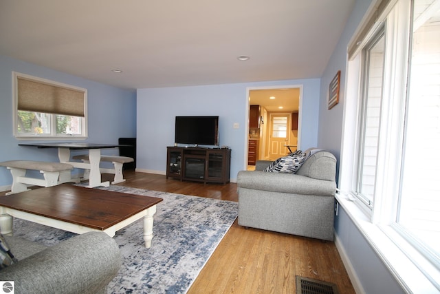 living area featuring wood finished floors, baseboards, and recessed lighting