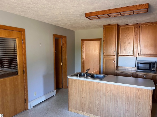 kitchen with sink, a baseboard heating unit, a textured ceiling, and a center island