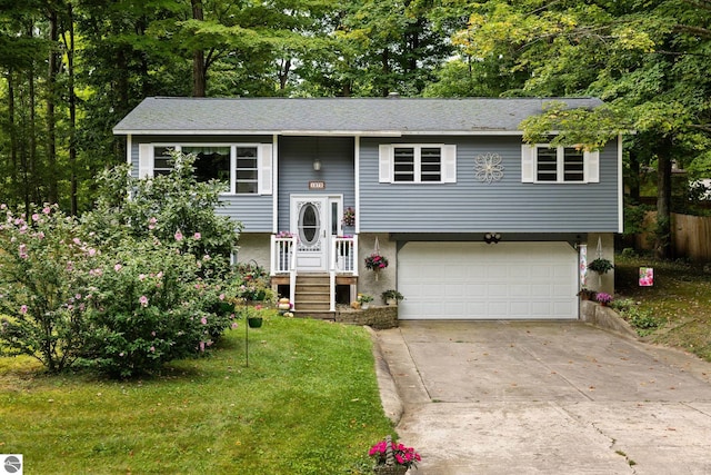 raised ranch featuring a garage and a front lawn