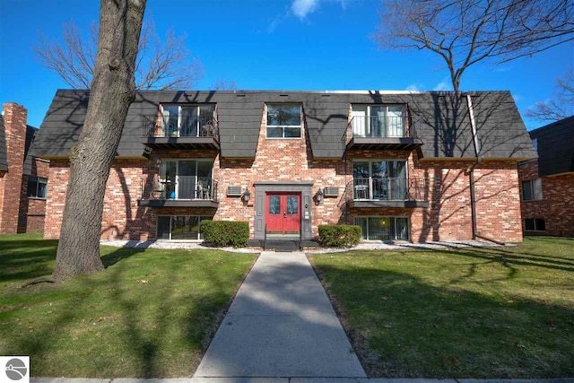 view of front facade featuring a front lawn and a balcony