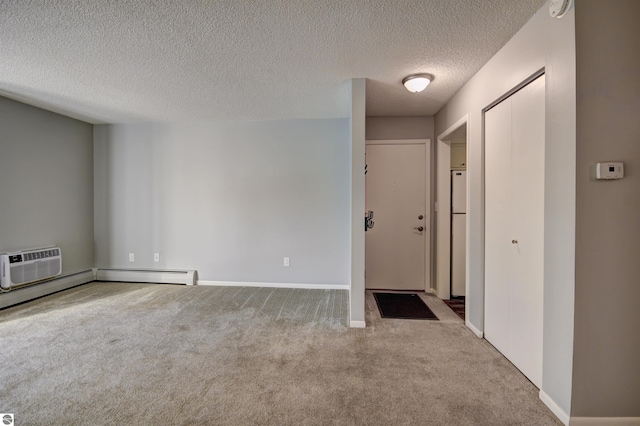 carpeted empty room with a textured ceiling, a baseboard heating unit, and a wall mounted air conditioner