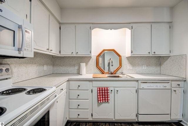 kitchen with white appliances, backsplash, white cabinetry, and sink