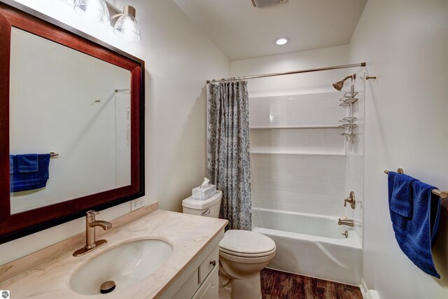 full bathroom with vanity, toilet, hardwood / wood-style flooring, and shower / tub combo with curtain