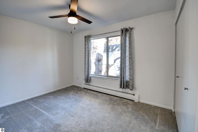 spare room with baseboard heating, carpet floors, and ceiling fan