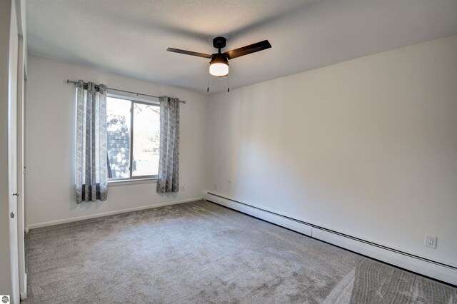 unfurnished room with a baseboard radiator, carpet flooring, and ceiling fan