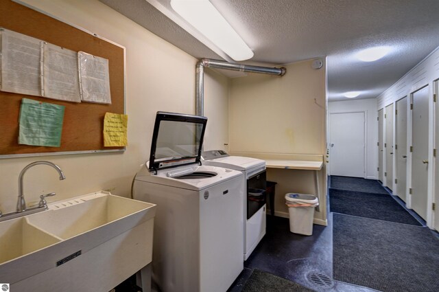 laundry room with washer and dryer, sink, and a textured ceiling