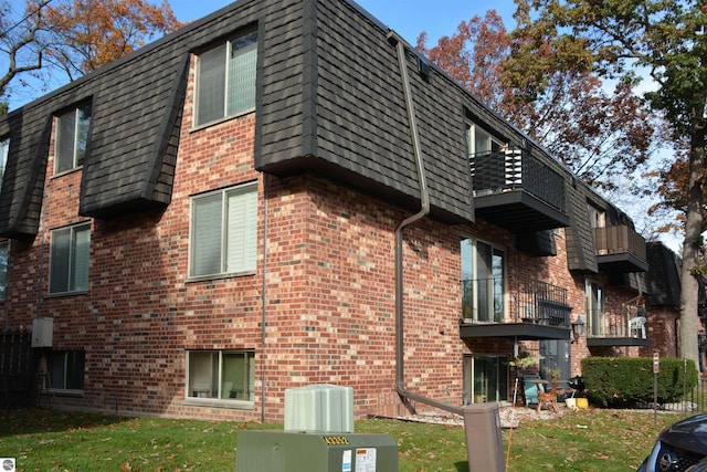 view of side of home with a balcony and a yard