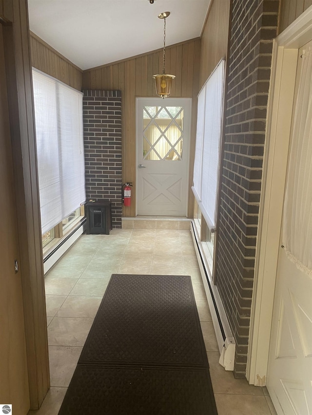 616 Holiday Dr, Bellaire, MI 49615 - foyer featuring a baseboard heating unit, lofted ceiling, baseboard heating, wood walls, and light tile patterned floors