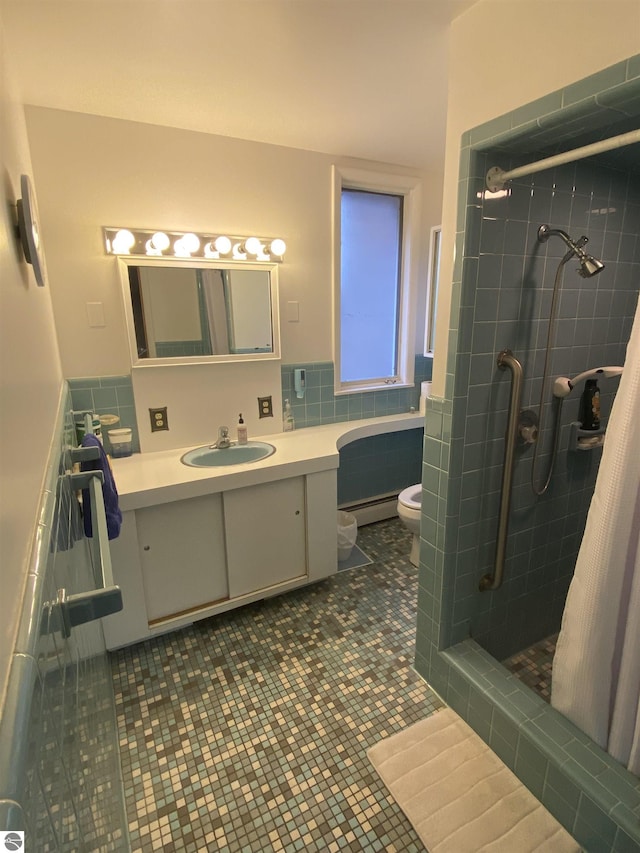 616 Holiday Dr, Bellaire, MI 49615 - full bath featuring baseboard heating, toilet, a shower stall, vanity, and tile walls