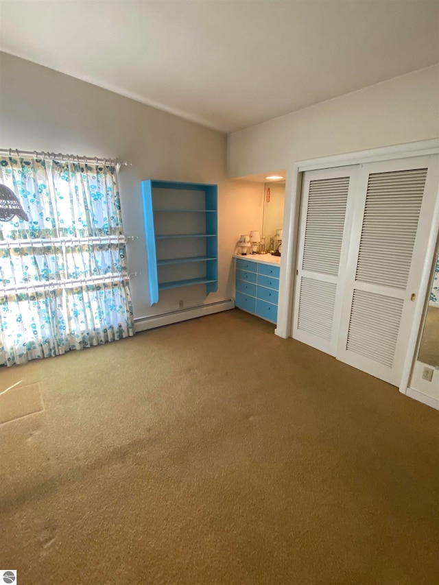 unfurnished bedroom featuring a baseboard radiator, carpet flooring, and a closet