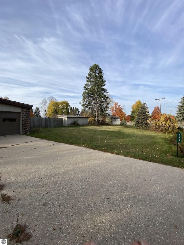 616 Holiday Dr, Bellaire, MI 49615 - view of yard with concrete driveway and a garage