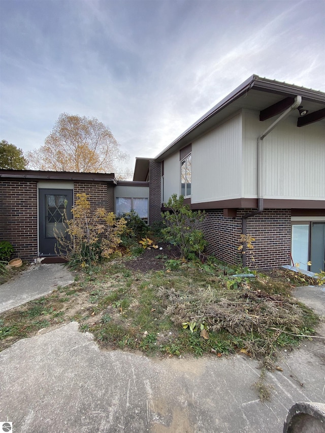 616 Holiday Dr, Bellaire, MI 49615 - view of side of home featuring brick siding