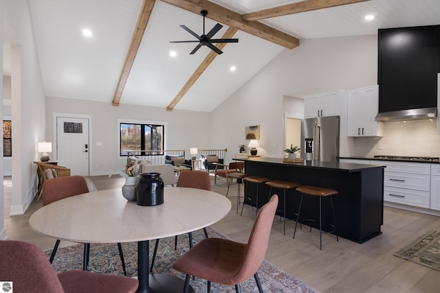 dining area with ceiling fan, beamed ceiling, high vaulted ceiling, and light wood-type flooring