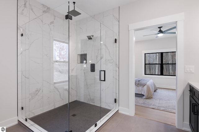 bathroom with hardwood / wood-style floors, ceiling fan, walk in shower, and vanity