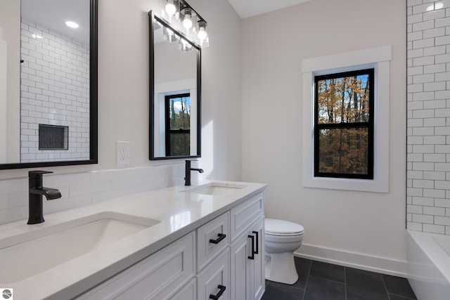 bathroom with toilet, vanity, tile patterned floors, and plenty of natural light