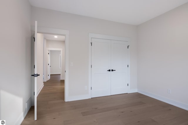 unfurnished bedroom with a closet and hardwood / wood-style floors