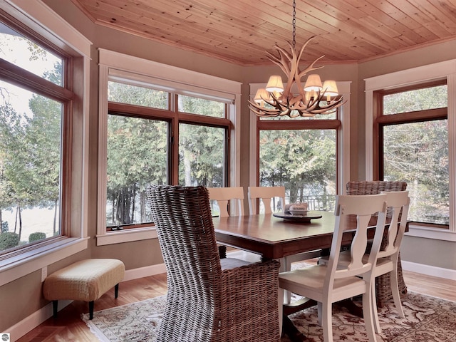 11320 Shippey Ln, Rapid City, MI 49676 - dining room featuring crown molding, an inviting chandelier, a healthy amount of sunlight, and light wood-style flooring