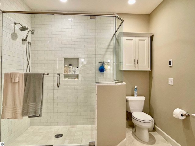 bathroom featuring toilet, an enclosed shower, and tile patterned flooring