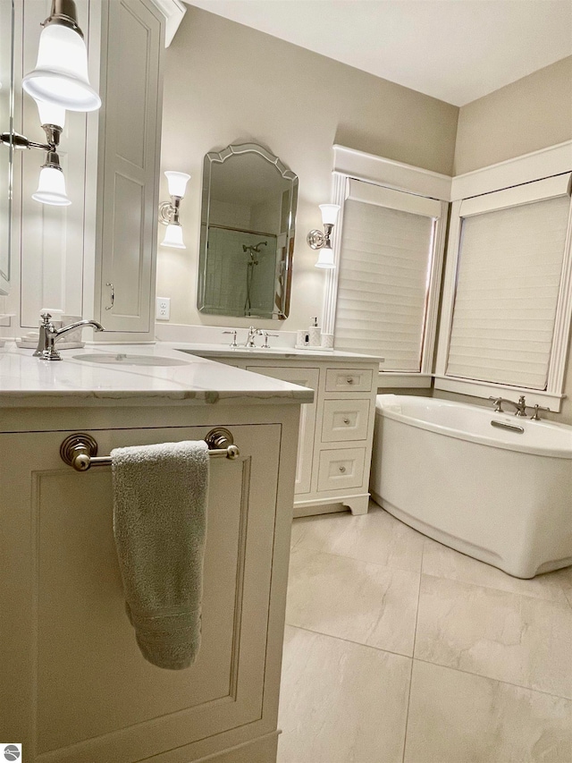 bathroom with vanity, a tub, and tile patterned floors