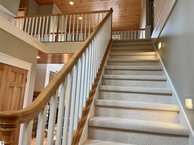 stairs with wood ceiling and a high ceiling