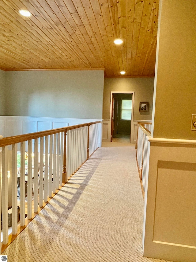 hallway with light carpet and wooden ceiling