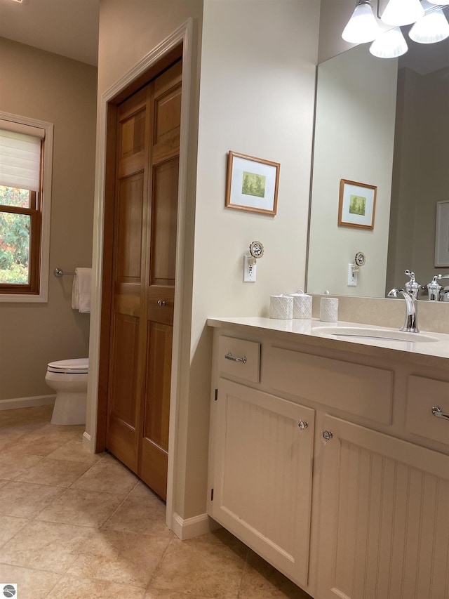 11320 Shippey Ln, Rapid City, MI 49676 - bathroom with baseboards, tile patterned floors, vanity, and toilet