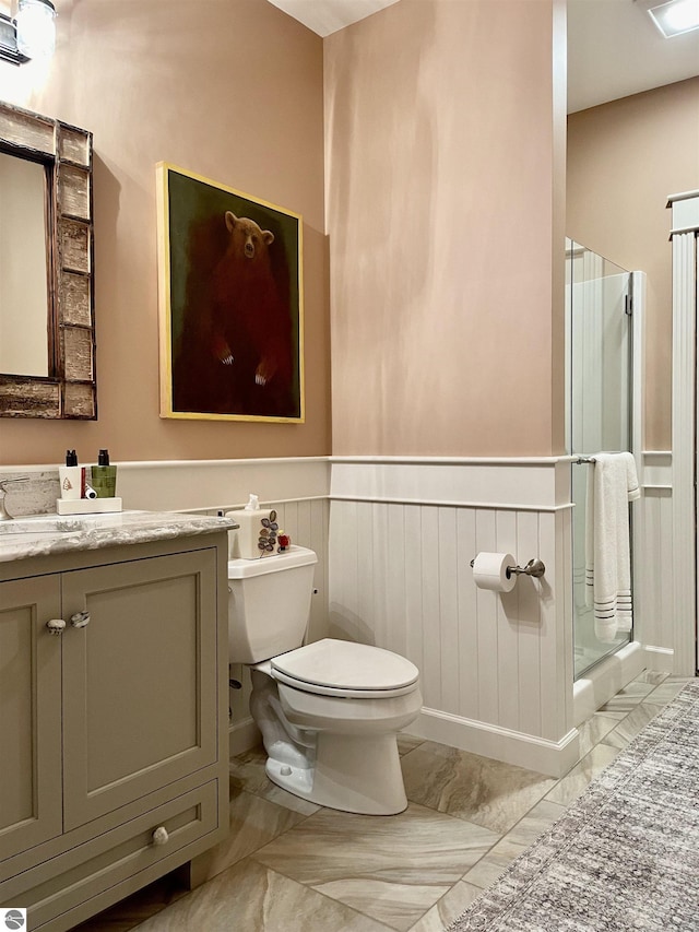 11320 Shippey Ln, Rapid City, MI 49676 - full bathroom with toilet, a stall shower, marble finish floor, and a wainscoted wall