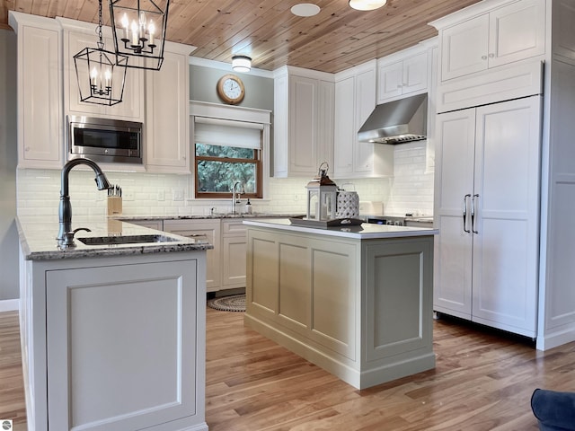 11320 Shippey Ln, Rapid City, MI 49676 - kitchen with light wood-style floors, wooden ceiling, ventilation hood, and stainless steel microwave