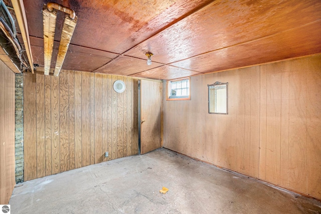 basement featuring wood walls